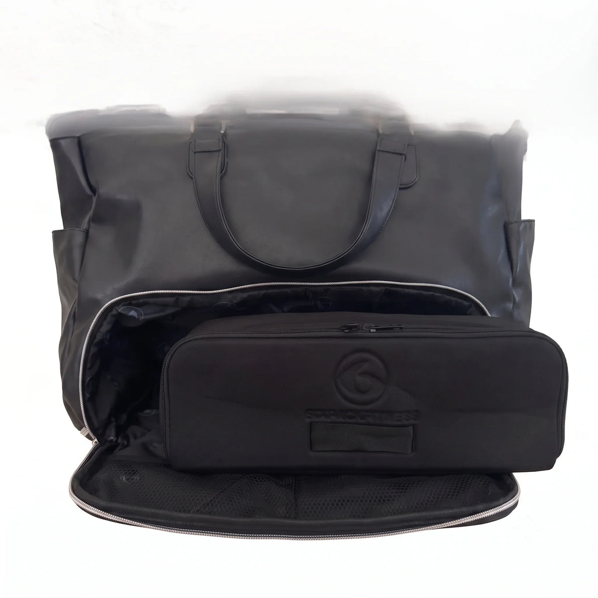 A black woman's handbag shown open, with a matching black zippered removable meal prep bag placed inside. The bag has a circular embossed logo and a small label patch.