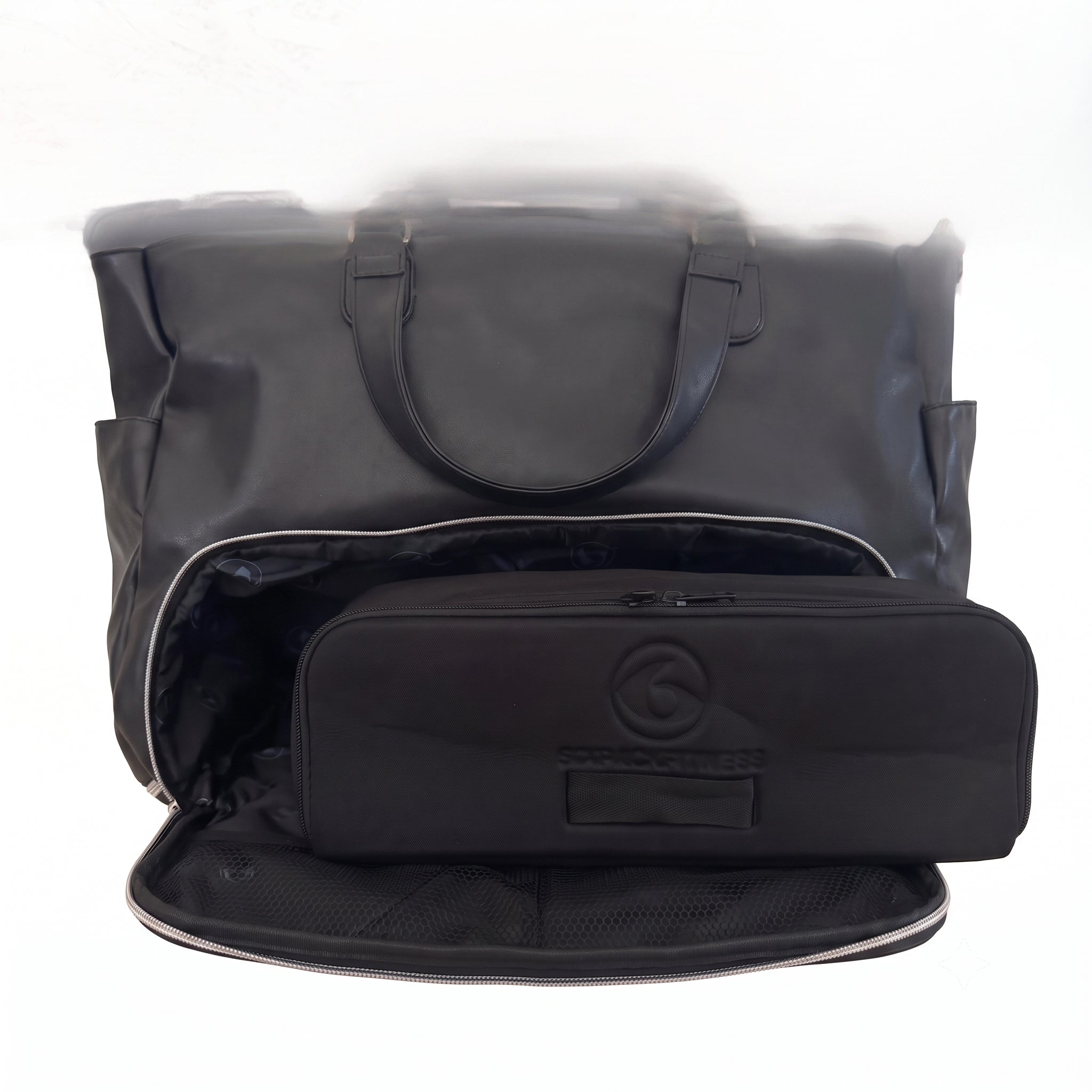 A black woman's handbag  shown open, with a matching black zippered removable meal prep bag placed inside. The bag has a circular embossed logo and a small label patch.